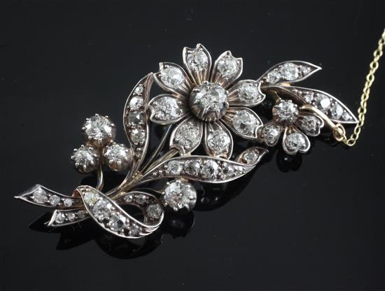 A gold, silver and diamond set floral spray brooch, 56mm.